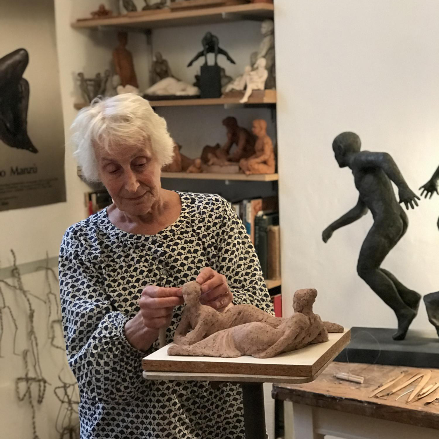 Woman working with clay sculpture of people