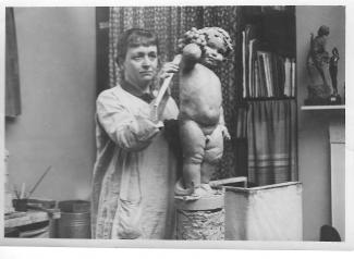 Anne Acheson putting her finishing touches to a sculpture called October in the 1920s