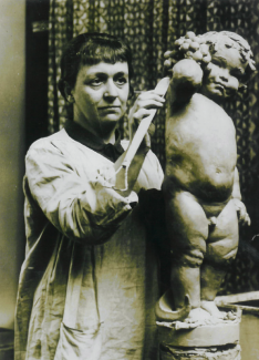 Anne Acheson working on a small sculpture of a child