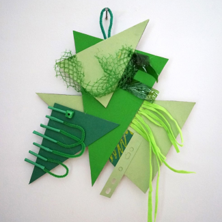 A collection of green shapes forming a collage hanging on a wall