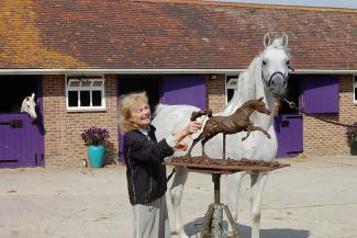 Lorne McKean FRSS with one of her horse sculptures in bronze, next to an actual horse