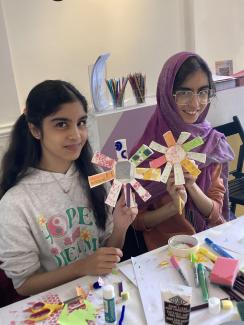 Two girls sharing the artwork they have made