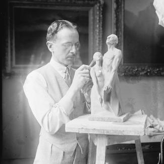 Black and white photo of Cecil Thomas working on a sculpture