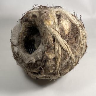 Burrow 2025. Plastic land drain, agricultural twine, barbed wire and chicken wire bound with felted insulation wool - natural and artificial. All salvaged materials from the countryside that link to biodiversity loss yet through their fusion explore the possibility of adaptation and evolution.