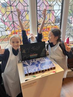 Three primary school students standing in front of a 3D puzzle