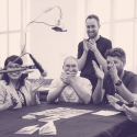 Black and white image of 4 people clapping around a table