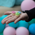 hand holding small iced gem sculptures in pink, green, blue