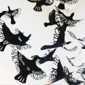 A flock of black birds created by the artist with Irish words cut out of their wings and body