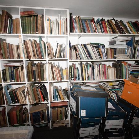 Shelves of archive materials in a dark, damp room