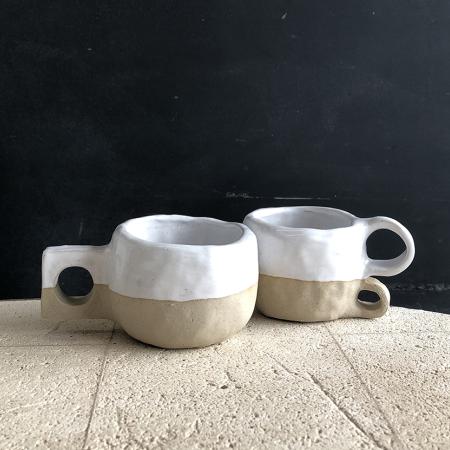 Two home made ceramic pots that look like mugs