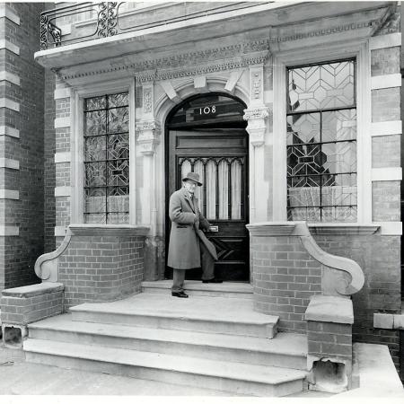 Cecil Thomas OBE FRBS entering Dora House 